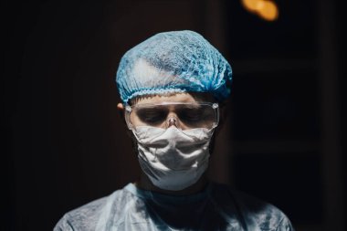 Gözlüklü ve koruyucu maskeli cerrahın portresi