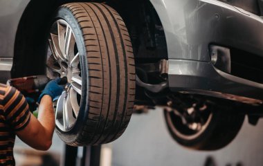 concept of replacing rubber car wheels, alloy wheels, a car on a lift.
