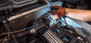 repairing a car engine in a car service, the hands of a mechanic unscrew the bolts