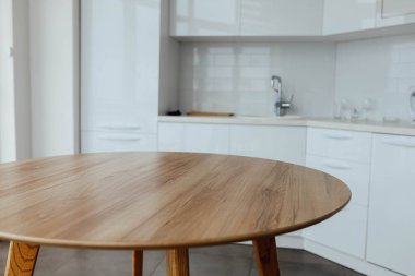 Beyaz, modern bir mutfağın arka planında ahşap bir masa. Yiyecek, yiyecek için bir yer..