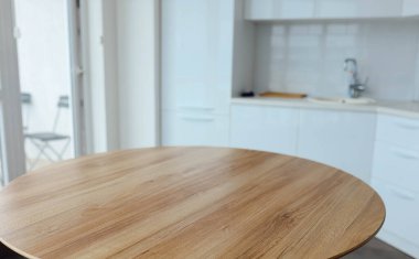 Beyaz, modern bir mutfağın arka planında ahşap bir masa. Yiyecek, yiyecek için bir yer..