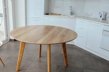 Beyaz, modern bir mutfağın arka planında ahşap bir masa. Yiyecek, yiyecek için bir yer..