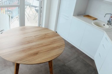 Beyaz, modern bir mutfağın arka planında ahşap bir masa. Yiyecek, yiyecek için bir yer..