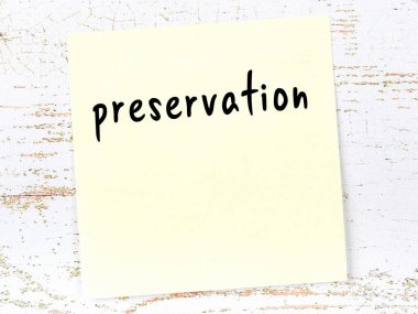 Tahta duvardaki sarı yapışkan notta el yazısı yazısıyla korunmuş.