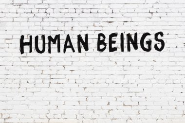 Üzerinde siyah boya olan beyaz tuğla bir duvar.