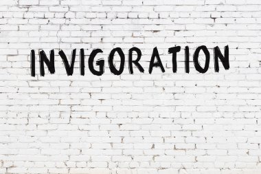 Yazılı beyaz tuğla duvar, el yazısıyla siyah boya ile canlandırılmış.