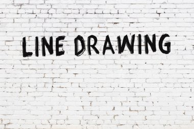 Siyah boyayla el yazısıyla çizilmiş beyaz tuğla bir duvar.