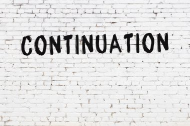 Yazı devam ediyor. Beyaz tuğla duvara siyah boya ile yazılmış..