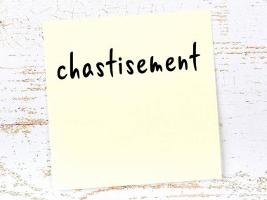 Tahta duvardaki sarı yapışkan notta el yazısıyla yazılmış ceza var.