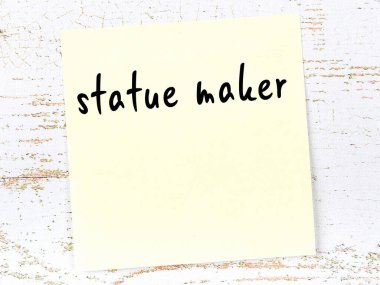 Tahta duvardaki sarı yapışkan notta el yazısıyla yazılmış heykel yapıcı var.