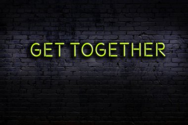 Üzerinde yazı olan neon levhası tuğla duvara karşı toplanın. Gece görünümü