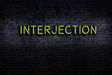 Duvara yazı kazınmış neon levhası. Gece görünümü