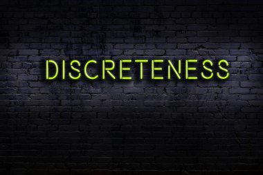 Tuğla duvara karşı yazıt ihtiyatsızlığı olan neon tabela. Gece görünümü