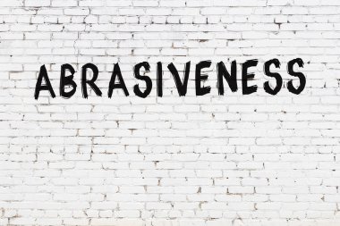 Yazı aşındırıcılığı beyaz tuğla duvara siyah boya ile yazılmış..