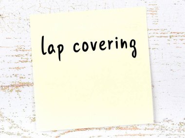 Kucak örtüsü hakkında hatırlatma kavramı. Tahta duvarda üzerinde yazı olan sarı yapışkan kağıt.