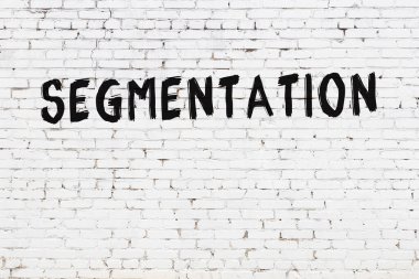 Üzerinde siyah boya olan beyaz tuğlalı bir duvar.