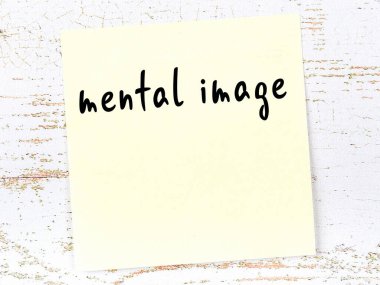 Ahşap duvardaki sarı yapışkan notta el yazısıyla yazılmış zihinsel resim var.