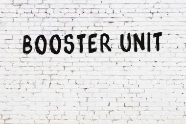 Üzerinde siyah boya bulunan beyaz tuğla bir duvar.