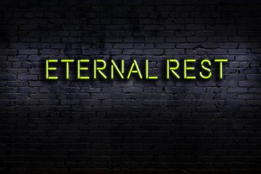 Tuğla duvara karşı sonsuz istirahat yazılı neon işareti. Gece görünümü