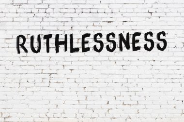 Beyaz tuğla duvara siyah boya ile yazılmış acımasızlık..