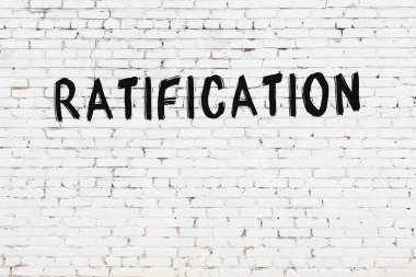 Beyaz tuğla duvara siyah boya ile yazılmış yazı onayı.