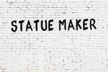 Üzerinde siyah boya olan beyaz tuğlalı bir duvar.