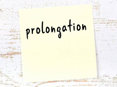 Tahta duvardaki sarı yapışkan notta el yazısıyla yazması uzatma var.