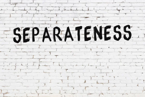 Yazı ayrımcılığı beyaz tuğla duvara siyah boya ile yazılmış..