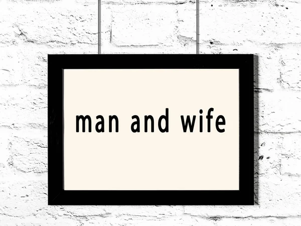 白いレンガの壁に掛かっている碑文の男と妻と黒の木製のフレーム — ストック写真