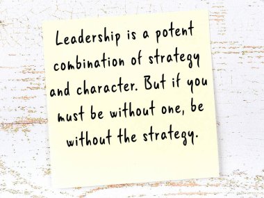 Sarı yapışkan not, ahşap duvarda el yazısıyla yazılmış zekice bir alıntıyla.