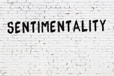 Beyaz tuğladan duvar, siyah boyayla yazılmış duygusallık.