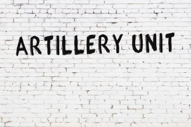 Üzerinde siyah boya bulunan beyaz tuğlalı bir duvar.