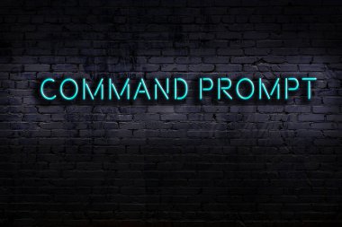 Üzerinde yazıt komutu olan neon işareti tuğla duvara karşı. Gece görünümü