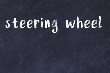 Üzerinde el yazısıyla yazılmış direksiyon simidi olan üniversite yazı tahtası.