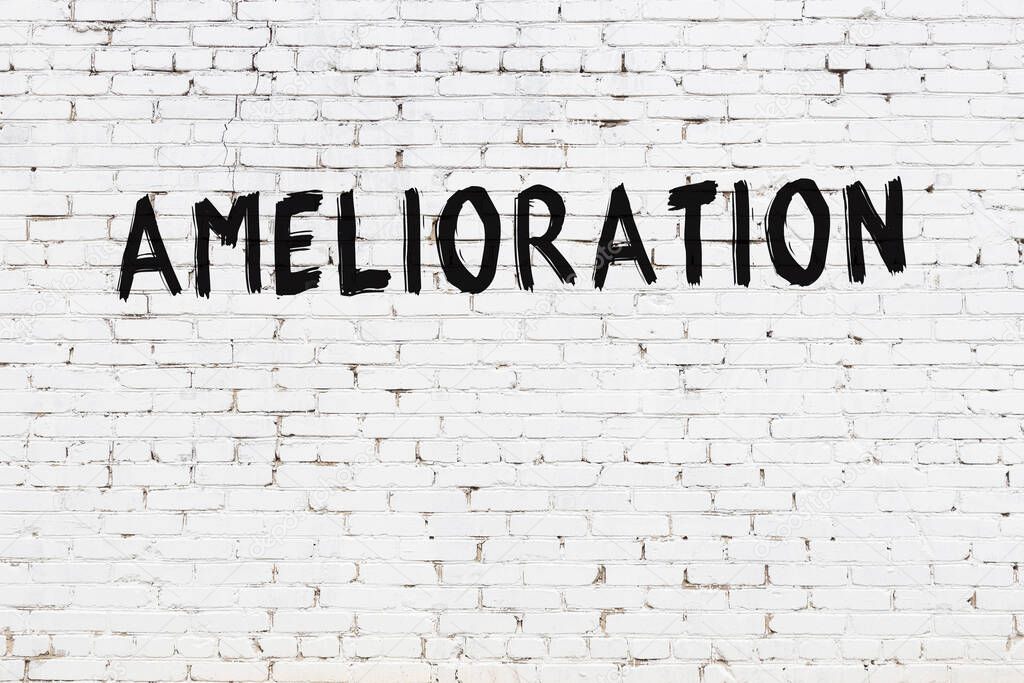 Inscription amelioration written with black paint on white brick wall.