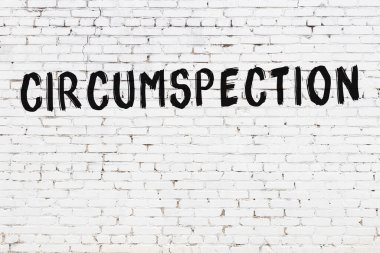 Siyah boyayla el yazısıyla yazılmış beyaz tuğladan bir duvar.