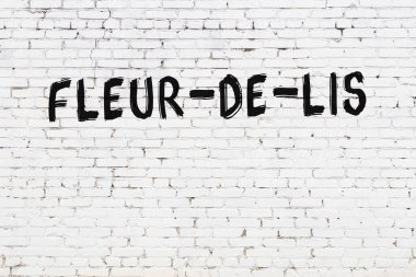 Üzerinde siyah boya bulunan beyaz tuğlalı bir duvar.