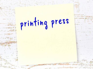 Matbaa hakkında hatırlatma kavramı. Tahta duvarda üzerinde yazı olan sarı yapışkan kağıt.