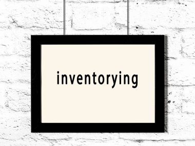 Siyah ahşap çerçeve ve beyaz tuğla duvarda yazılı envanter. 