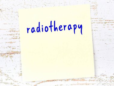 Radyoterapiyi hatırlatma kavramı. Tahta duvarda üzerinde yazı olan sarı yapışkan kağıt.