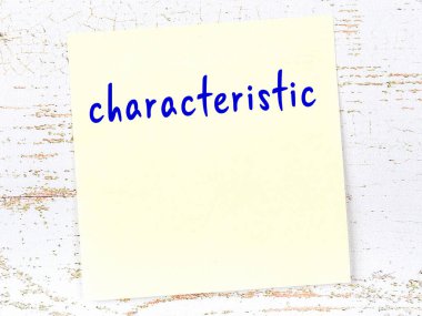 Karakteristik hakkında hatırlatma kavramı. Tahta duvarda üzerinde yazı olan sarı yapışkan kağıt.
