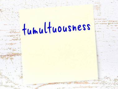 Ahşap duvardaki sarı yapışkan notta el yazısı karışıklığı var.