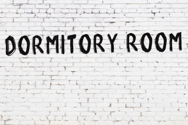 Beyaz tuğla duvara siyah boya ile yazılmış bir yatakhane odası..
