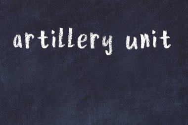 Tebeşir el yazısıyla yazılmış topçu birliği siyah masanın üzerinde.