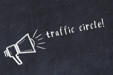 Hoparlörün tebeşir çizimi ve siyah masanın üzerine el yazısıyla yazılmış trafik çemberi