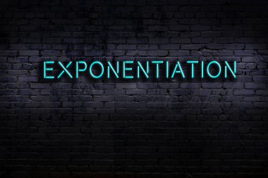 Tuğla duvara karşı üstel yazıtlı neon işareti. Gece görünümü