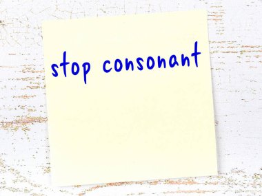 Ahşap duvarda el yazısıyla yazılmış sarı yapışkan not.