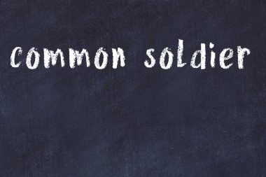 Tebeşir el yazısı siyah masada sıradan bir asker.