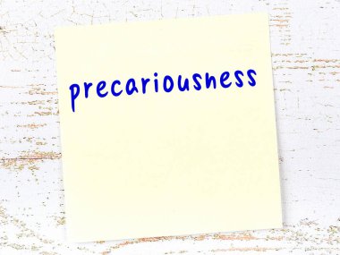 Tahta duvardaki sarı yapışkan notta el yazısı güvensizlik var.