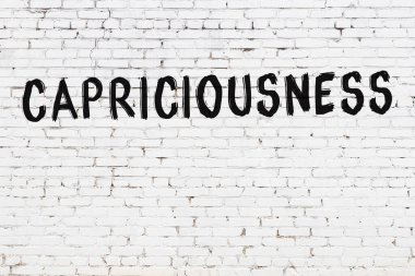 Yazıt kaprisleri beyaz tuğla duvara siyah boya ile yazılmış..